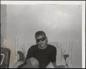 Young woman wearing sunglasses in bed