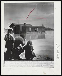 "River Stay Away From My Door!"-- That was the hope and prayer of thousands up and down the Missouri river today as "Old Muddy" continued on its worst rampage in history. These unidentified persons watch as the River completely surrounds their home.