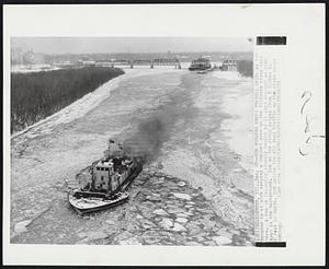 Ice Breaker Keeps Channel open: An ice breaker is at work keeping a channel open on the Illinois river near here. A tow is following closely behind as it goes through an open span in the background. Ice on the river ranges from 8 inches to 2 feet in depth, but unlike the old days traffic on the river keeps moving.