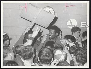 Fans Surround Celtics' Bill Russell at Logan Airport last night as over 300 greeted team after clinching eastern Division title.