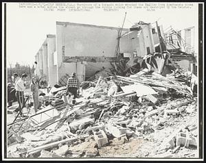 Survivors of a tornado which wrecked the English Cove Apartments shown here and a motel across the street go through the rubble looking for items not destroyed by the twister.