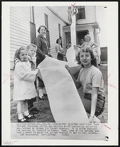 Long-Winded Cristmas Greetings- This 75-foot Christmas letter was written by 80 Louisville relatives and friends of Airman 3/c Rodney Scheele. It is being prepared for mailing to Scheele in Korea. Here, some of the authors who took a month to write the letter stretch it out to full length.