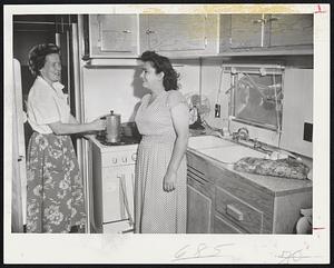 Trailer Neighbors - Mrs. Walter Marhafer, left, and Mrs. Lucille Bouvier, next-door neighbors at the Lincolnwood Park trailer site in Worcester, talk over their narrow escapes during the tornado. They stand in a trailer kitchen.