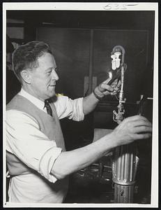 Keeper of the Flame -- William Newman, one of two lamp supervisors in employ of the City of Boston, makes an adjustment to brighten the glow.