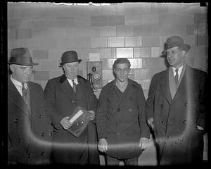 Four unidentified men standing by a police department telephone