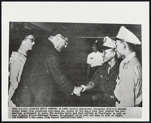 Russian Envoy Greeted in Laos--Soviet Ambassador Alexander Nikitich Abramov shakes hands with paratroop Capt. Kong Le, leader of the Aug. 9 coup that toppled the pro-American government in Laos. The Russian envoy had just arrived in Vientianne to call on Laos Premier Prince Souvanna Phouma. Mrs. Abramov is at left and Kong Le side at right.