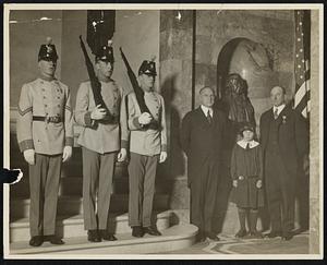 Scene at presentation of bust of John Adams at State House today. Gov. Fuller, 9 year old Abigail Adams, who unveiled bust, and Sen. Wellington Wells, president of the Society of Sons of the Revolution in Massachusetts. At the left are members of the guard of honor in Colonial costume.