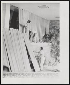 Better Safe Than Sorry--Quick to respond to the weather bureau's storm warning report is the Miami Daily News building crew shown putting up the metal protective shutters over the large plate glass windows in the papers lobby.