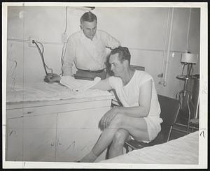 Getting Heat Treatment for tender right arm is Jim Russell, Braves switch hitting centerfielder, from Dr. Charles K. Lachs, team trainer, in clubhouse before last night's game with St. Louis Cardinals.