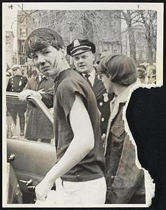 Demonstrator Bloodied--One of four anti-Vietnam demonstrators, Benjamin Barth, 16, entering police car to be taken to hospital after attack by hecklers on Boston Common Saturday.