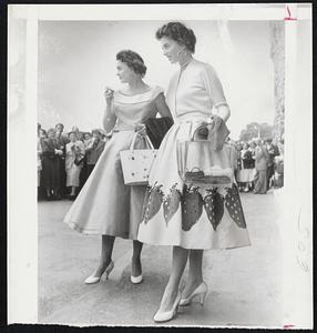 Tennis "Widows" at Wimbledon-Mrs. Dolly Seixas, left, and Mrs. Tony Trabert, wives of U. S. tennis stars Vic Seixas and Tony Trabert, set a style note for tennis "widows" while their husbands compete for the British title at Wimbledon, England. Mrs. Seixas wears a pale blue linen frock trimmed with white collar and Mrs. Trabert sports a strawberry pattern.