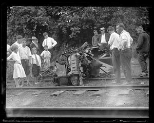 People look at wreckage on railroad tracks