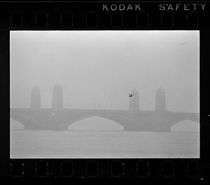 A seagull flies in mist over the Longfellow Bridge, Boston