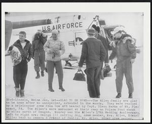 Lincoln, Maine. - Glad To Be Home - The Allen family are glad to be home after an unexpected, extended in the woods. They were rescued by a helicopter crew from Dow AFB headed by Capt. Glenn marks of Mt. Pleasant, PA. The Allen's were marooned at their camp on Folsom Pond about 50 miles north of Bangor. Monday was the Allen's 17th Wedding Anniversary,. Left to right are: George III carrying dog, crew member, Mrs. Allen, Edward Willey back to camera & friend of family, Mr. Allen, other crew member.