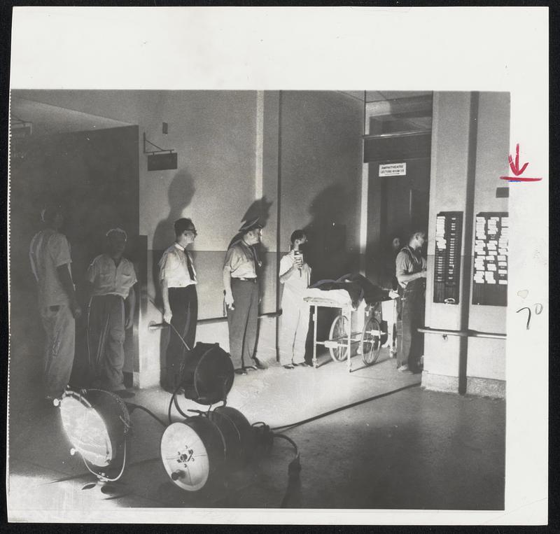 Battery of fire department searchlights provide light at New York’s Mt. Sinal Hospital as patient on wheeled stretcher is moved along a corridor during city’s huge power failure.