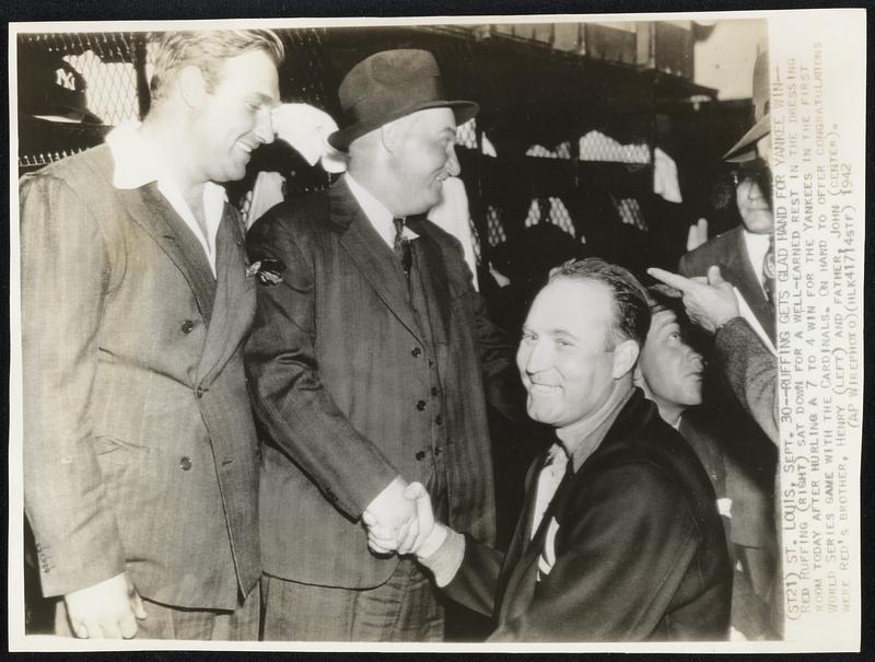 Ruffing Gets Glad Hand for Yankee Win -- Red Ruffing (right) sat down for a well-earned rest in the dressing room today after hurling a 7 to 4 win for the Yankees in the first World Series Game with the Cardinals. On hand to offer congratulations were Red's brother, Henry (left) and father, John (center).