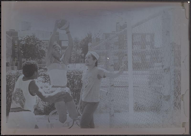 Tico Garcia (left) plays basketball with his twin, Daco Garcia, while Rainier Rosado looks on