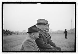 Boston Park Department Commissioner William Long seated next to three other men, an unidentified man kneeling to his right