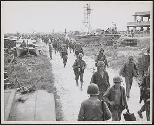 Marines move along a supply-lined road on Peleliu to take up positions on the front lines