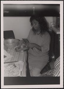 A woman sitting at a table and preparing food