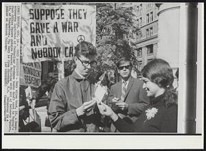 Coed Assistance - Gary Allen Wood, 18, a Massachusetts Institute- of Technology freshman burns draft card in Boston's Post Office Square outside Federal Building with aid of DeCourcy Squire, 19, of Morgantown, Va. Gary is from Stratham, N.H. DeCourcey is a junior at Antioch College.