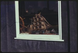 Window display of a model ship and ship's wheel