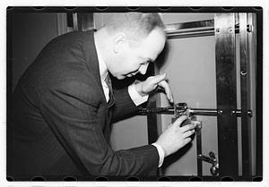A man demonstrating how to break into a safe