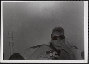 Young woman lying on bed with sunglasses