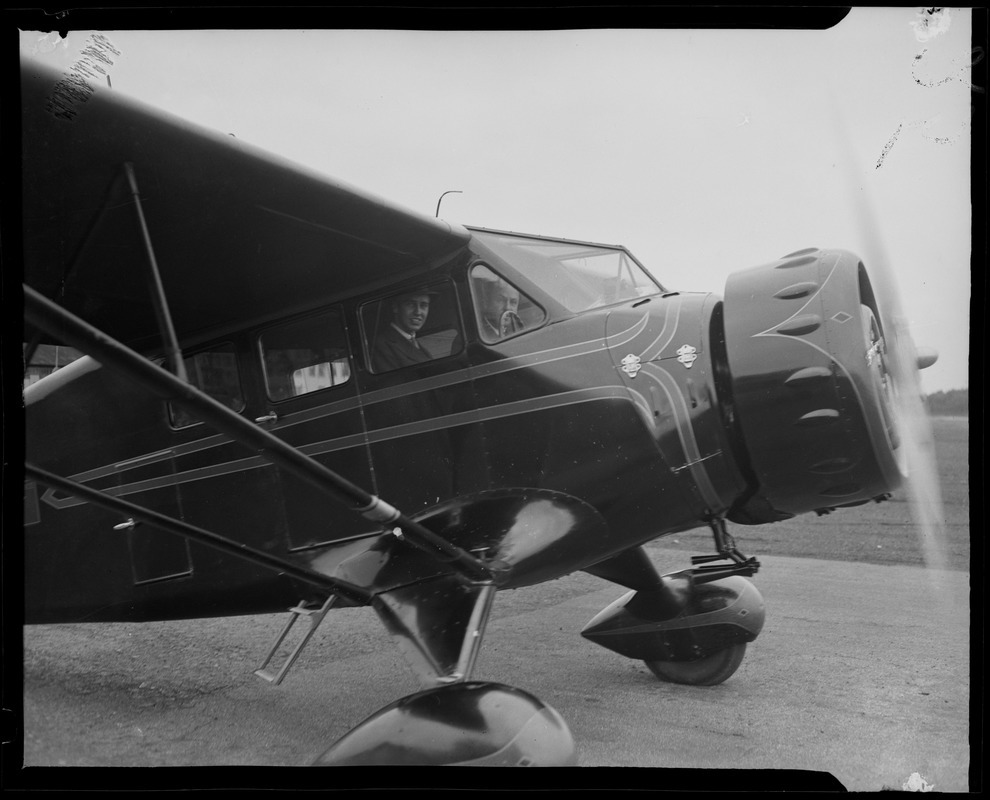 John Roosevelt with an unidentified man standing beside an airplane