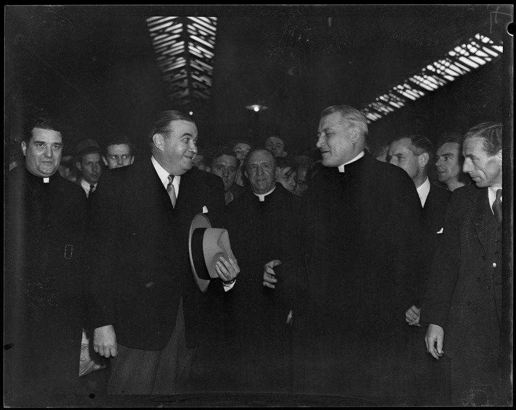 Gov. Paul Dever and Rev. Cushing surrounded by group of men