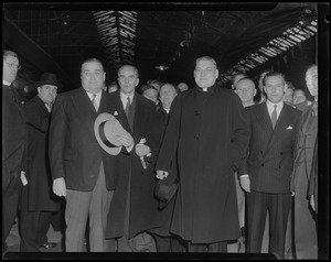 Gov. Paul Dever and Rev. Cushing surrounded by group of men