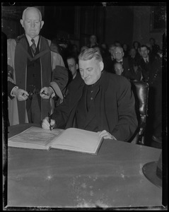 Rev. Cushing signing the book prior to receiving the Freedom of the City