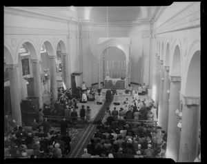 A crowd seated in church attending a religious ceremony