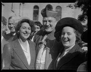 Two women stand with Rev. Cushing