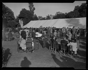People seated outdoors alongside a tent
