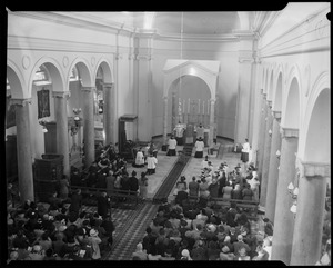 A crowd seated in church attending a religious ceremony