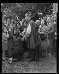 Woman kneeling, kissing the hand of Rev. Cushing