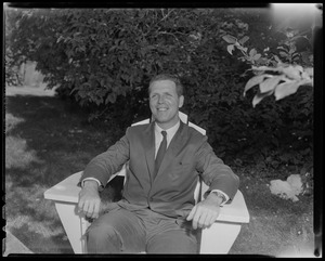 Mayor Kevin White sitting in chair outdoors, with flora in background