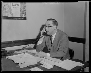Man sitting at desk, on the phone