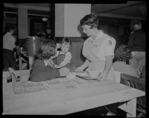 Red Cross volunteer serving a woman and child