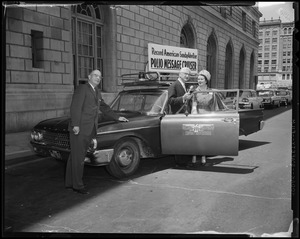 Dr. Albert B. Sabin (middle) and two others stand next to the Record American-Sunday Advertiser Polio Message Cruiser