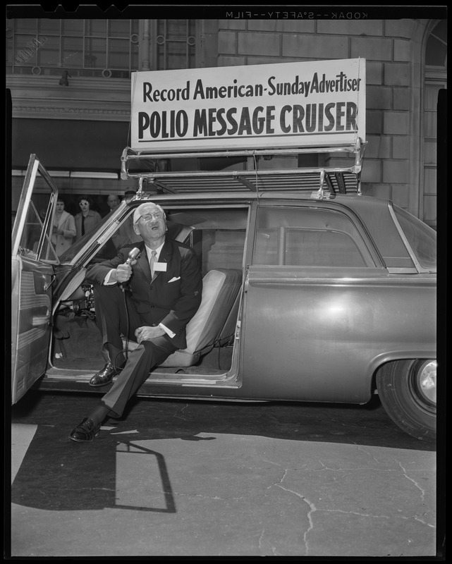 Dr. Albert B. Sabin speaking with a microphone in the Record American-Sunday Advertiser Polio Message Cruiser