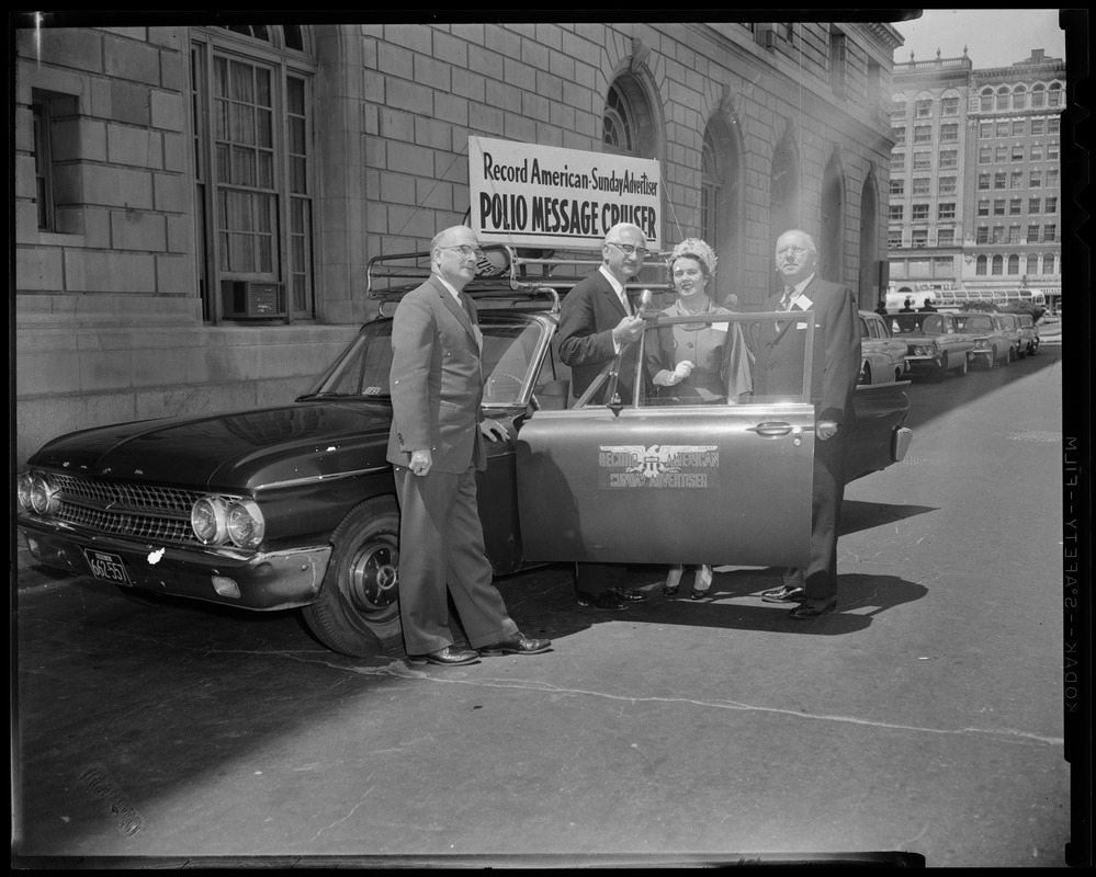 Dr. Albert B. Sabin (second from left) and three others posing with the Record American-Sunday Advertiser Polio Message Center Cruiser