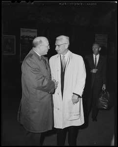 Dr. Albert B. Sabin (right) shaking hands with a man while another looks on