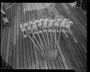 Crew team (including Gov. Leverett Saltonstall) with oars on boat dock, shot from above