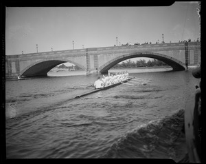 Crew team rowing (including Gov. Leverett Saltonstall) on water with bridge in background