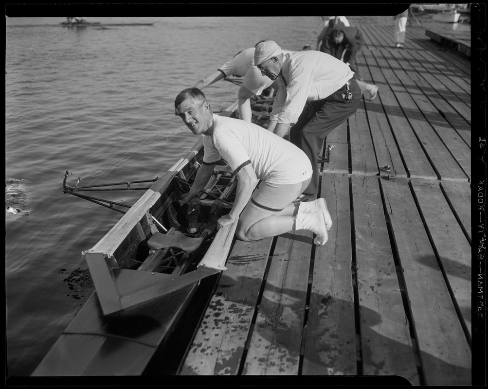 Gov. Leverett Saltonstall leans over a boat in the water