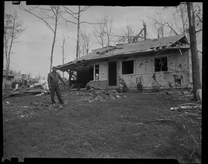 Man outside ruined house
