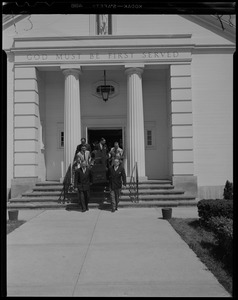 Pallbearers walking out of a church with coffin