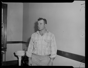 Man in flannel shirt standing near wall